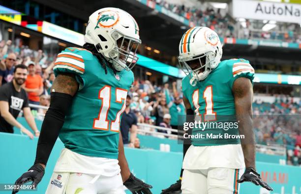 Jaylen Waddle and DeVante Parker of the Miami Dolphins celebrate a touchdown against the New England Patriots at Hard Rock Stadium on January 09,...