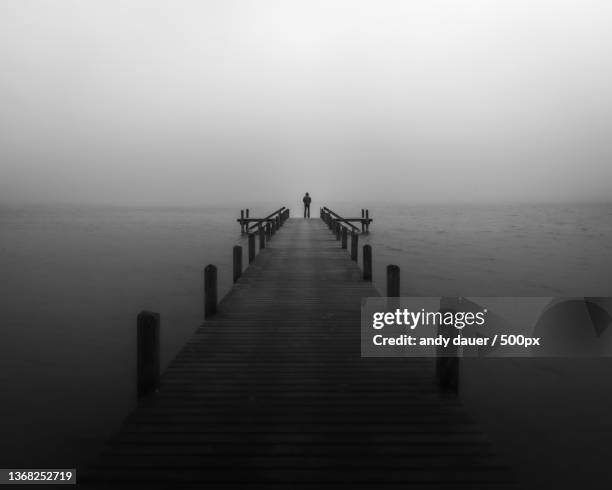 out of the dark,silhouette of pier on sea against sky - long jetty stock pictures, royalty-free photos & images