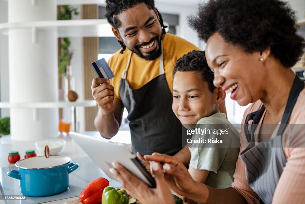 Family preparing dinner and ordering groceries online