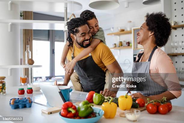 family preparing a healthy meal in the kitchen - mom preparing food stock pictures, royalty-free photos & images