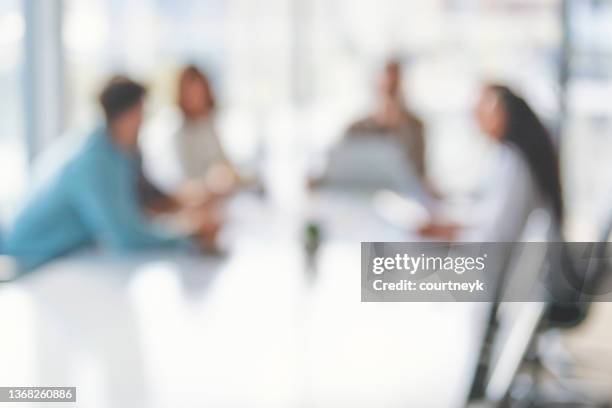 defocussed image of business people during a meeting. - blurred office imagens e fotografias de stock