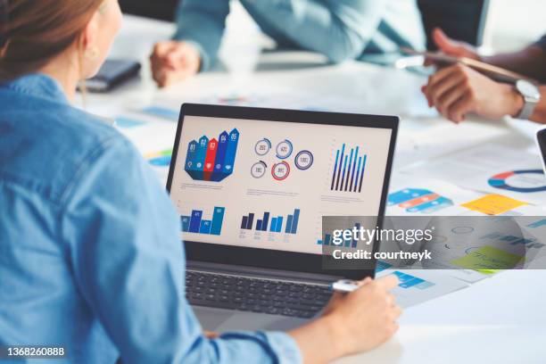 multi racial group of people working with paperwork on a board room table at a business presentation or seminar. - budget stockfoto's en -beelden