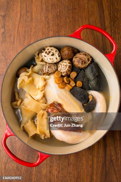 plat traditionnel pour le nouvel an chinois - ingrédients bruts du poulet et ragoût de fruits de mer séchés dans un pot en fonte émaillée rouge - prosciutto stock photos et images de collection