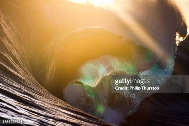 beautiful close up of crashing wave in front of golden sun - perfect storm stock pictures, royalty-free photos & images