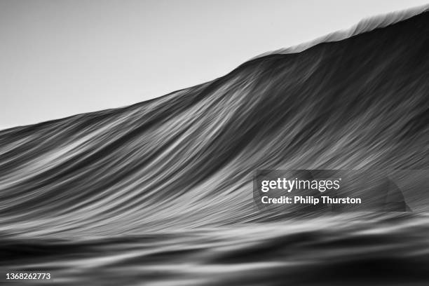 black and white slow shutter of wave rising on oceans surface - black white imagens e fotografias de stock