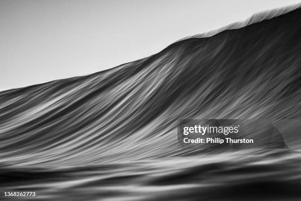 black and white slow shutter of wave rising on oceans surface - naturkraft bildbanksfoton och bilder
