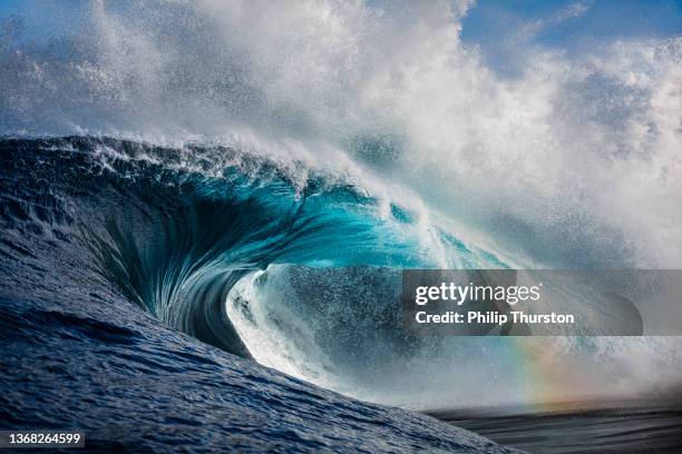 powerful crashing ocean wave with hint of rainbow shining through - autoriteit stockfoto's en -beelden