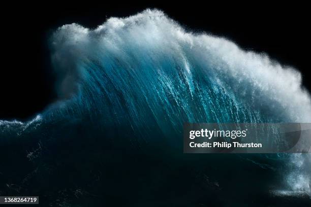 powerful ocean wave exploding into the air in front of dark sky - big wave stock pictures, royalty-free photos & images