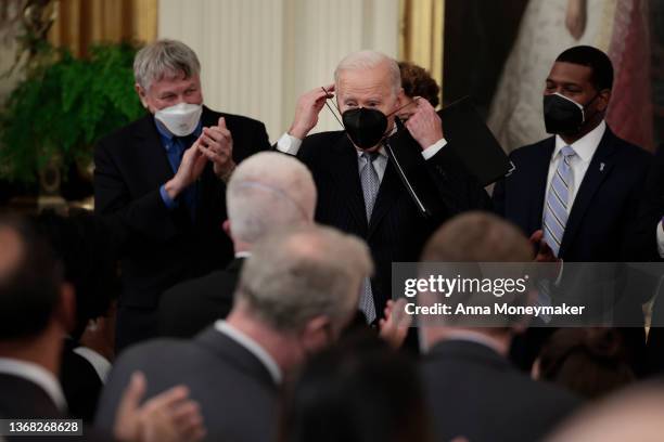 President Joe Biden puts his face mask on after giving remarks during a Cancer Moonshot initiative event in the East Room of the White House on...