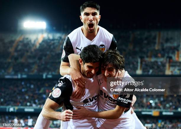 Goncalo Guedes of Valencia CF celebrates with his teammate Bryan Gil and Carlos Soler of Valencia CF after scoring the opening goal during during the...