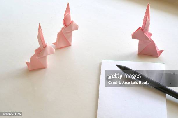 pink paper origami bunny on background. crafts made of paper. the minimal concept of easter or the year of the rabbit. easter - easter fantasy stockfoto's en -beelden