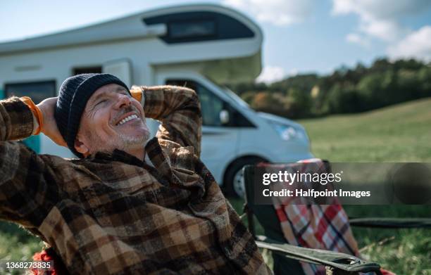 senior man camping with caravan in nature. - trailer imagens e fotografias de stock