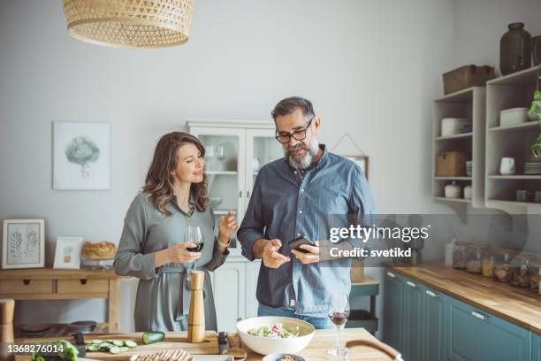 making memories at home. - woman drinking phone kitchen stockfoto's en -beelden