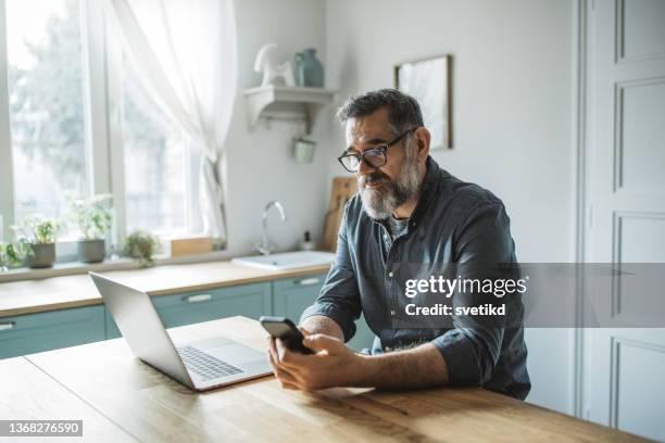 working during isolation period - middle aged man stock pictures, royalty-free photos & images