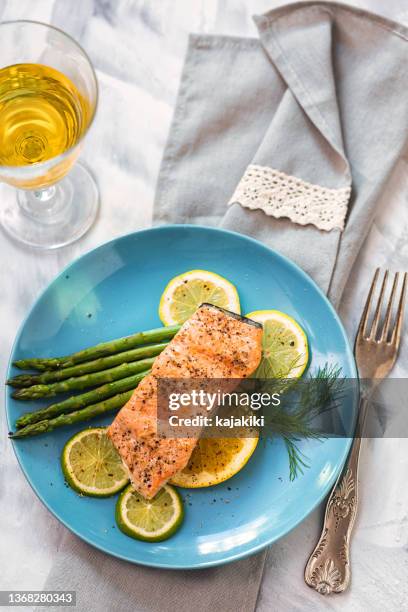 grilled fillet of salmon with asparagus served on a plate - geroosterde zalm stockfoto's en -beelden