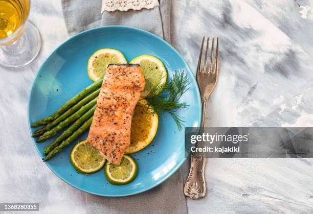 grilled fillet of salmon with asparagus served on a plate - geroosterde zalm stockfoto's en -beelden