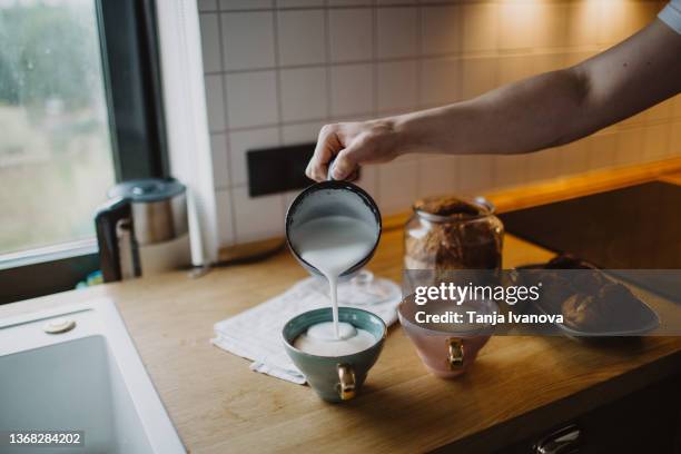 man's hand makes coffee at home - coffee milk stockfoto's en -beelden