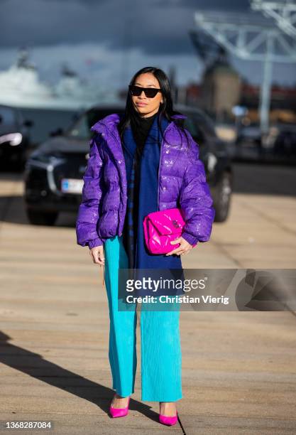 Miki Cheung seen wearing purple down feather jacket, turquoise pants, pink bag outside Saks Potts during Copenhagen Fashion Week Autumn/Winter 2022...