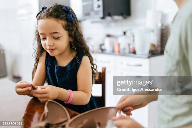 little girl eating easter egg in the kitchen - open day 4 stock pictures, royalty-free photos & images