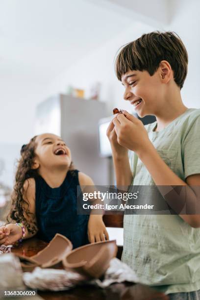 lustige kinder essen ostereier in der küche - child loves chocolates stock-fotos und bilder