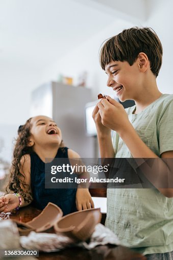 Fun kids eating easter eggs in the kitchen Fun kids eating easter eggs in the kitchen