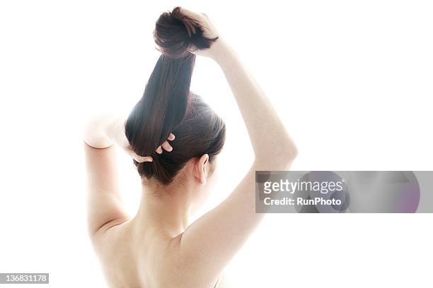 young woman styling her hair - 髪に手をやる　女性 ストックフォトと画像
