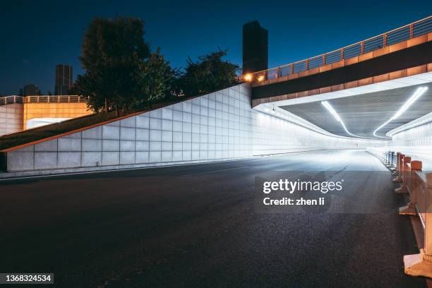 entrance of the tunnel at night - túnel de carretera fotografías e imágenes de stock