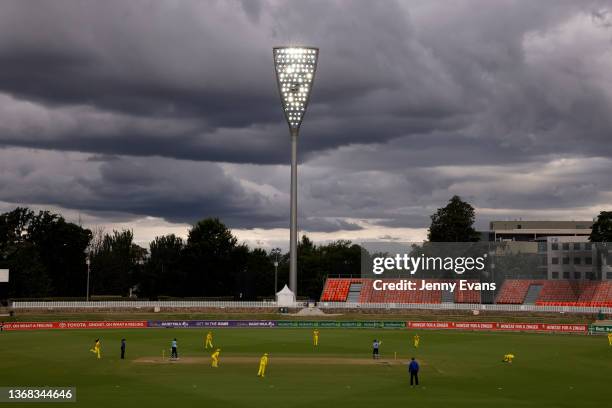 Storm clouds are seen as Megan Schutt of Australia bowls to Nat Sciver of England and Amy Jones of England during game one of the Women's Ashes One...