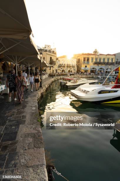 tourists enjoying sunset from harbour, rethymno - crete rethymnon stock pictures, royalty-free photos & images