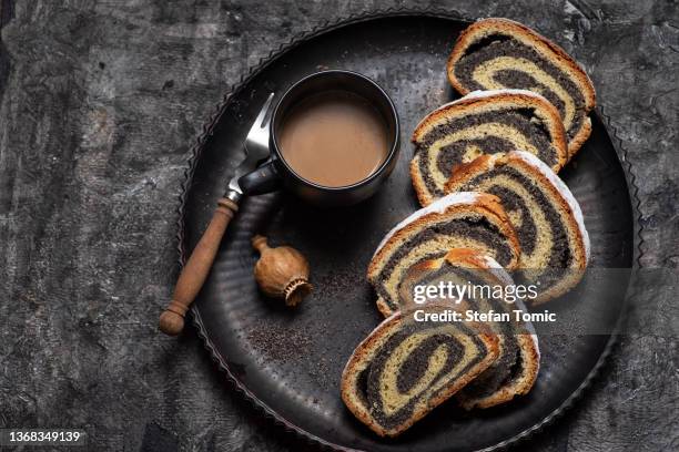 sliced poppy seed strudel sweet roll on a rustic board - poppy seed stock pictures, royalty-free photos & images