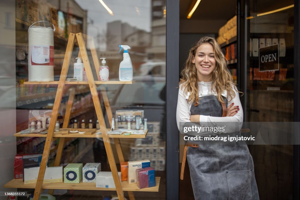 Proud female small business owner in front of the store