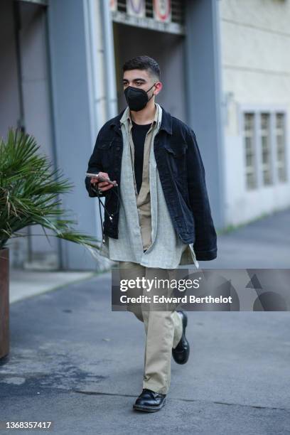 Guest wears diamond earrings, a black t-shirt, a brown shirt, a pale yellow and blue checkered print pattern shirt, a black denim jacket, beige suit...