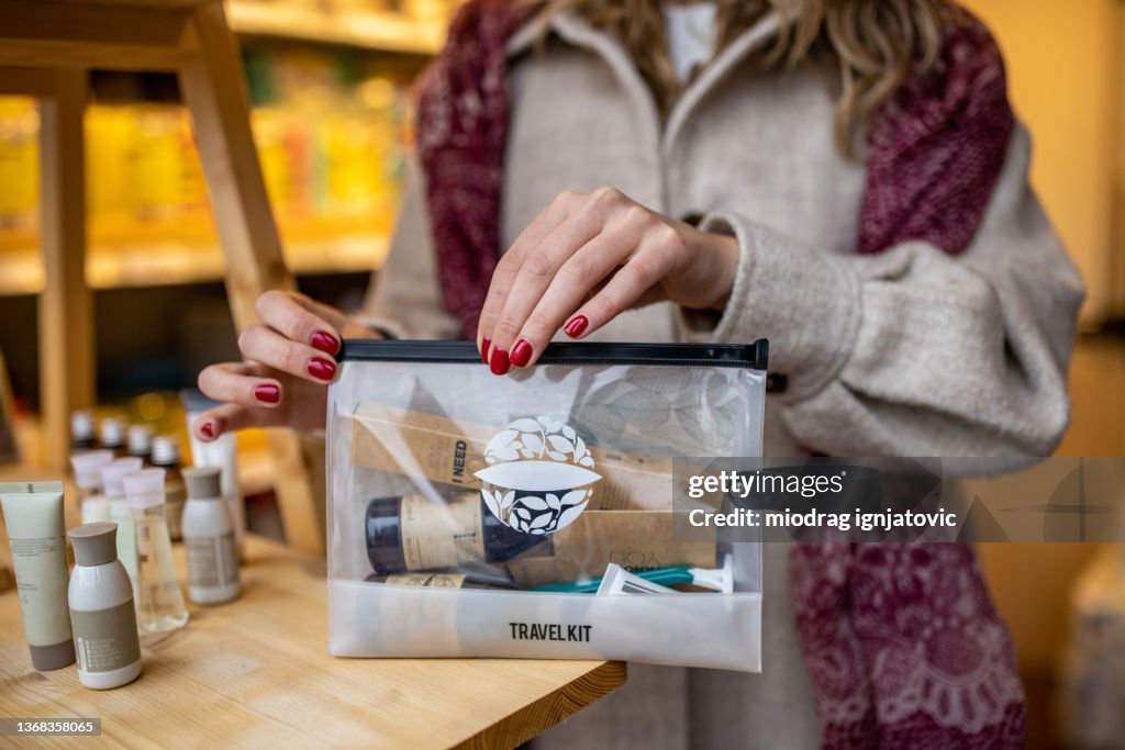 Unrecognizable saleswoman packing the travel size hygiene product at the vanity case
