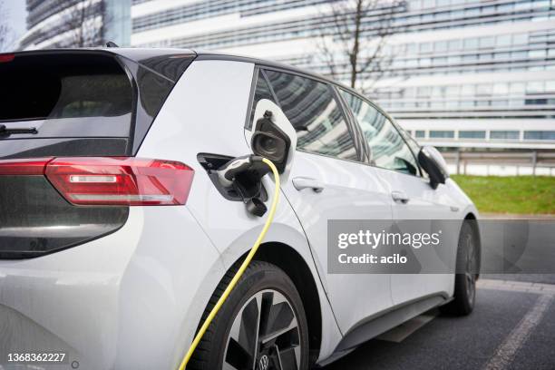 white vw id 3 electric car connected to a recharging station - volkswagen stockfoto's en -beelden