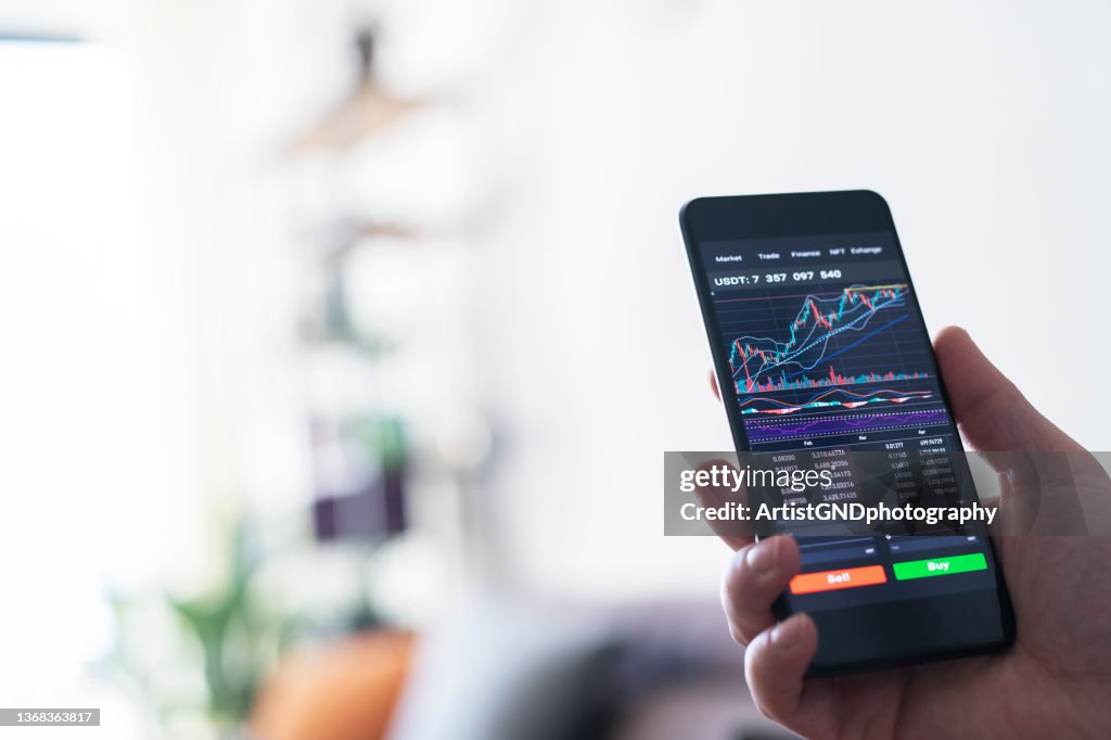 Empresário lendo análise do mercado financeiro de ações no smartphone.