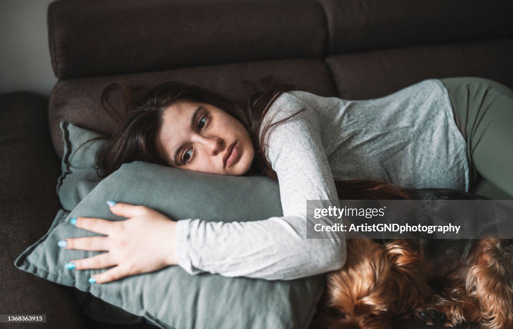 Mujer triste en el sofá.