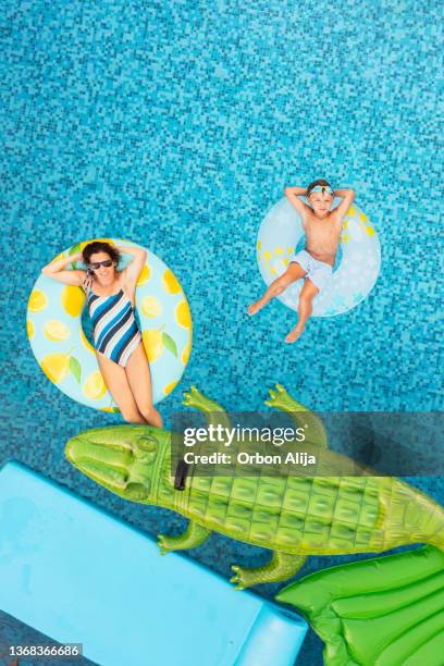 mère avec fils sur gonflable - piscine photos et images de collection