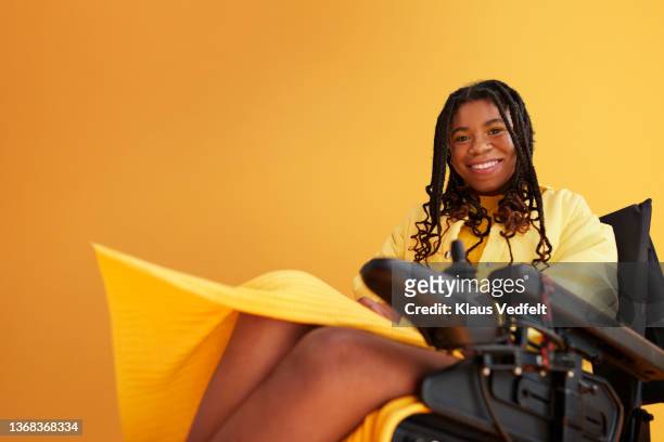 smiling woman with disability sitting in wheelchair - long bright yellow dress stock pictures, royalty-free photos & images