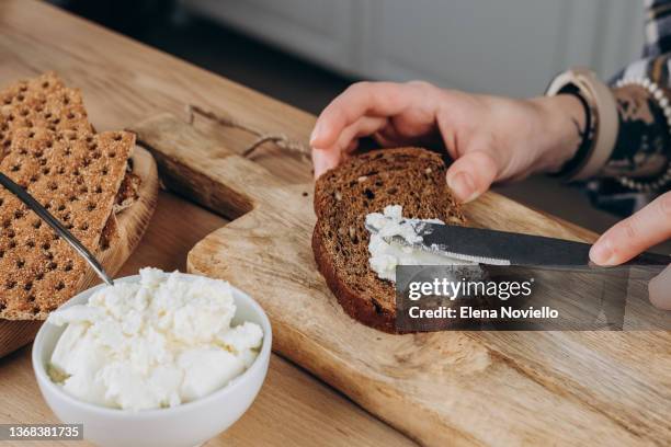 mom  making avocado toast for breakfast or lunch, women's hands spread soft cheese on multigrain bread, healthy eating - making sandwich stock pictures, royalty-free photos & images