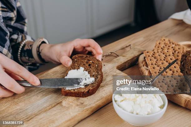 mom  making avocado toast for breakfast or lunch, women's hands spread soft cheese on multigrain bread, healthy eating - lunch cheese foto e immagini stock