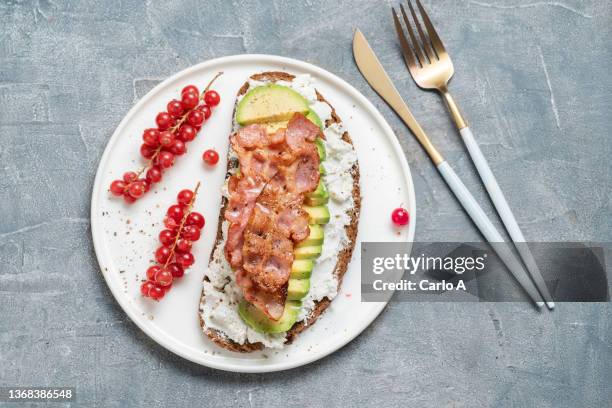 avocado bacon on brown bread for breakfast - spek stock-fotos und bilder