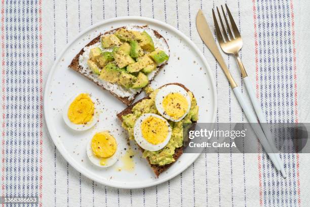 breakfast of avocado and boiled eggs - hard boiled eggs stock-fotos und bilder