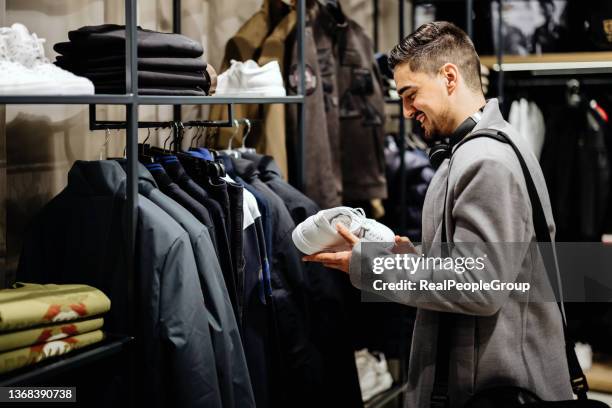 jeune homme d’affaires faisant ses courses dans un magasin de vêtements - chaussure en toile photos et images de collection