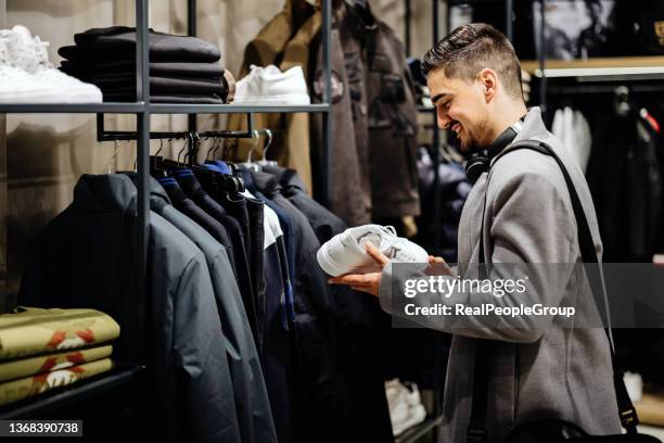 young businessman shopping in clothes store - choosing shoes stock pictures, royalty-free photos & images