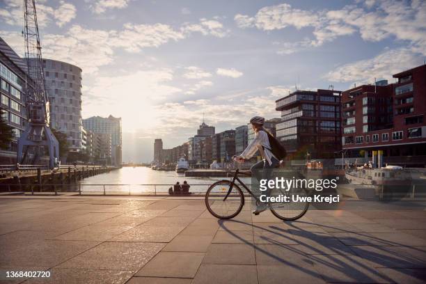 young woman riding a bike - city stock-fotos und bilder