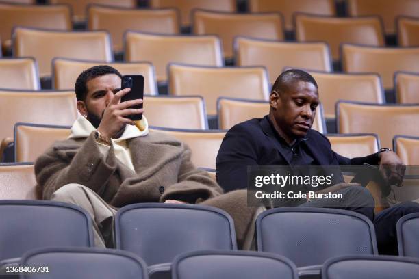 Toronto rapper Drake sits with Toronto Raptors president Masai Ujiri during the first half of NBA game between the Toronto Raptors and the Miami Heat...