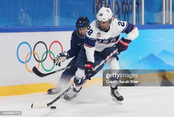 Amanda Kessel of Team United States battles for possession with Minnamari Tuominen of Team Finland during the Women's Ice Hockey Preliminary Round...