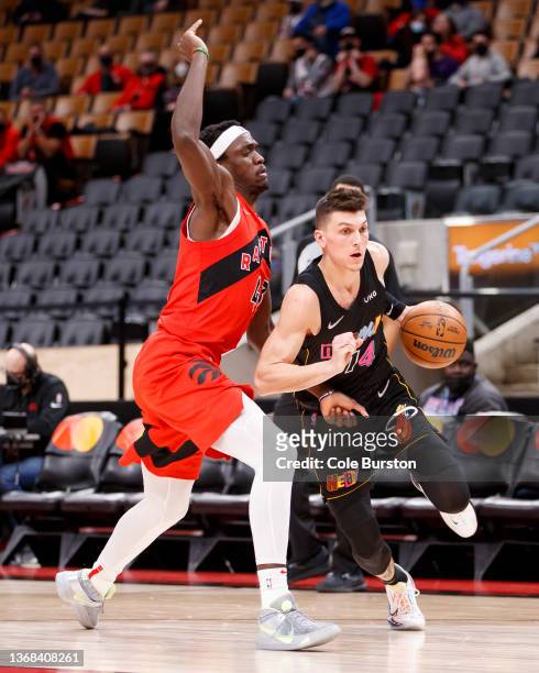 Tyler Herro of the Miami Heat dribbles by Pascal Siakam of the Toronto Raptors during the first half of their NBA game at Scotiabank Arena on...