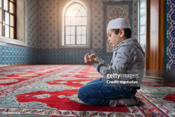 cute little muslim boy praying in mosque - salah islamic prayer stockfoto's en -beelden