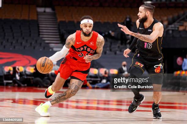 Gary Trent Jr. #33 of the Toronto Raptors dribbles by Caleb Martin of the Miami Heat during the first half of their NBA game at Scotiabank Arena on...